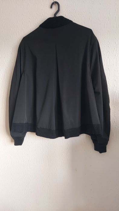 Casaco de malha trabalhada à  frente com bolsos.