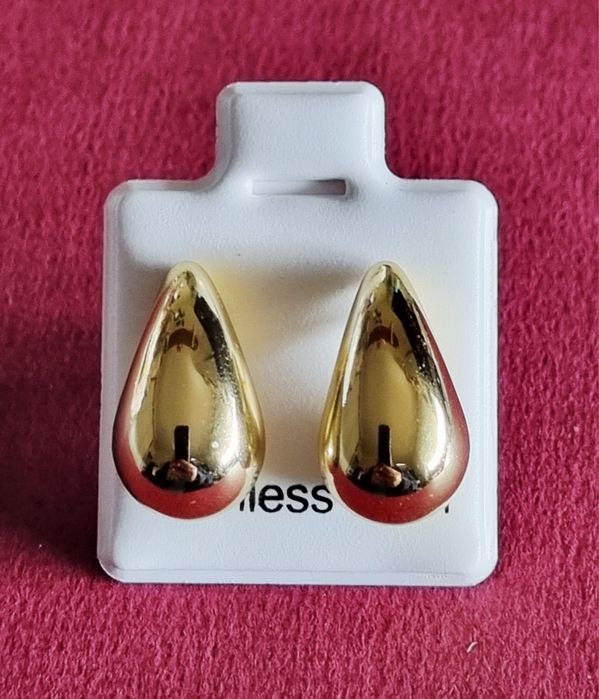 Pequenos brincos dourados, em aço, em forma de gota. De pico