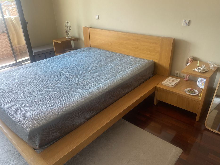 Quarto com cama de casal, colchao e mesinhas de cabeceira