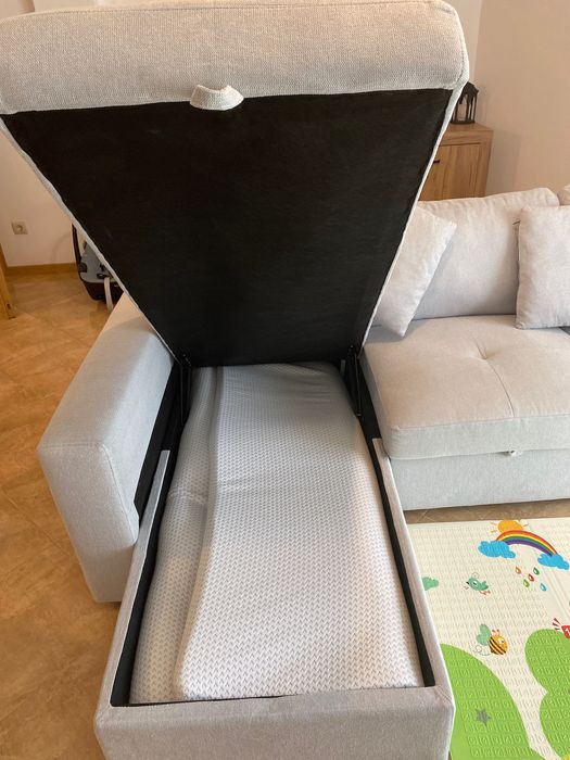 Sofá cinzento com chaise long e cama