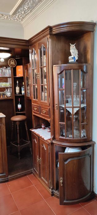 Bar de canto com vidros facetados, balcão, vitrines e 2 bancos
