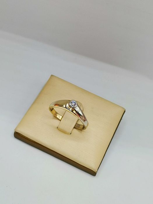 Pierścionek z centralnym brylantem w złocie.