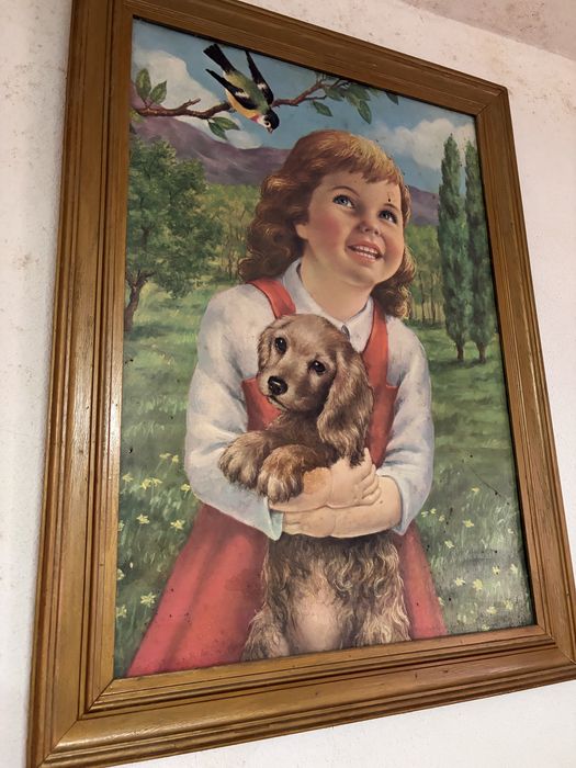 Quadro decorativo antigo retratando uma criança com um cão, num estilo artístico popular de meados do século XX.