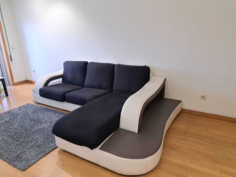 Sofá em couro branco em formato de L com detalhes em cinza