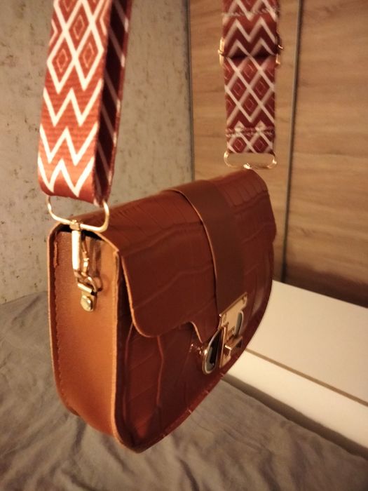 Brązowa torebka typu listonoszka.