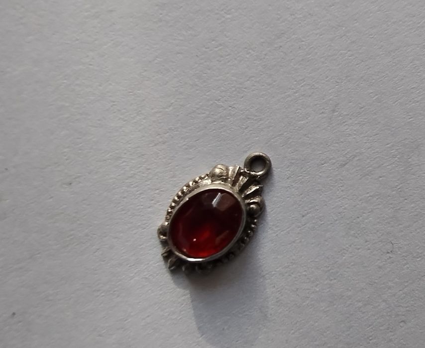 Srebrna zawieszka z czerwonym oczkiem