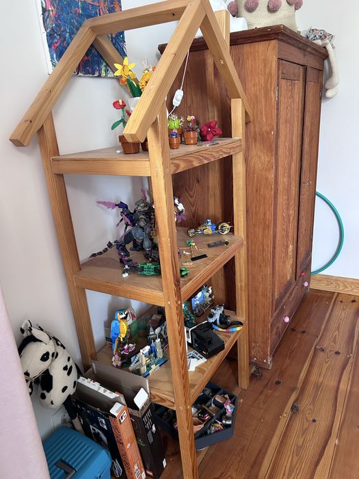 Drewniany regał w kształcie domku.