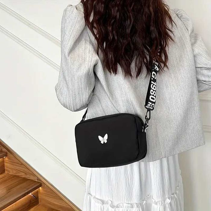 Чорна сумочка, біла сумочка та червона з метеликом