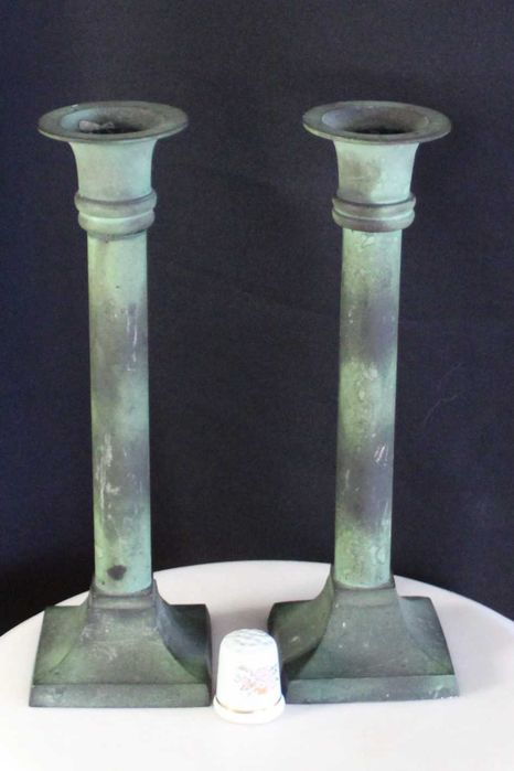 Par de castiçais antigos de latão com pátina esverdeada.