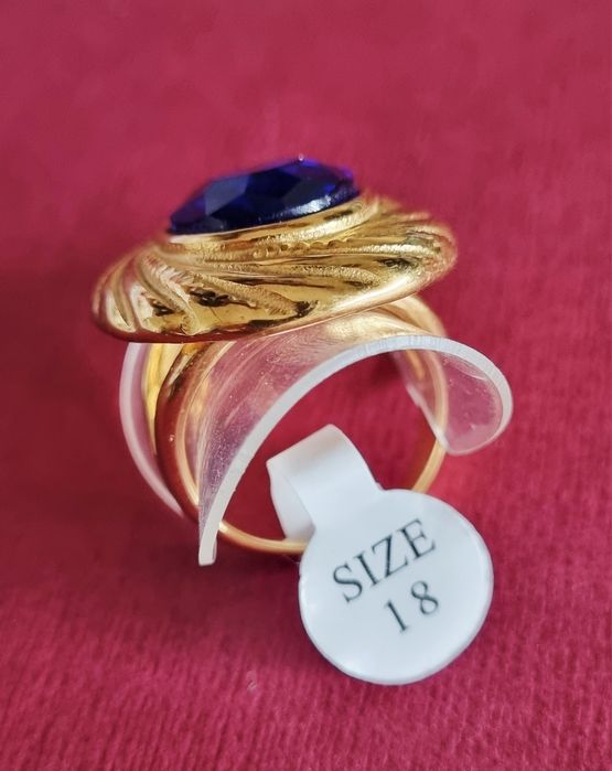 Anel dourado, em aço, com grande pedra oval azulão. T18