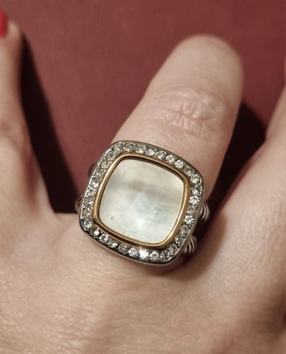 Anel prateado, em aço, com madrepérola quadrada rodeada de zirconias.