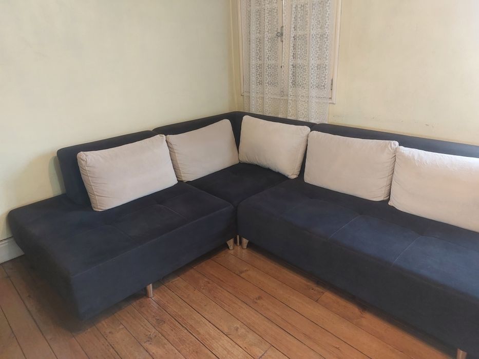 Sofá preto com almofadas beje