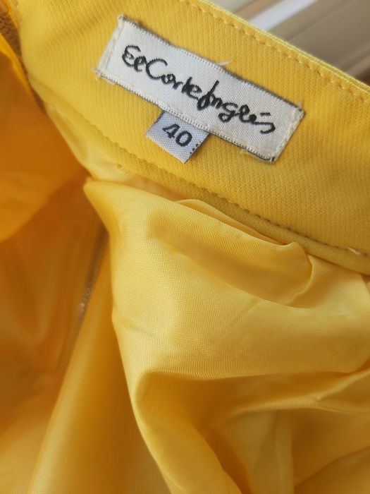 Saia encorpada, rodada em amarelo torrado.