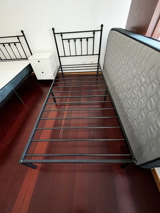 Duas camas em aço preto fosco, com colchões e capas de colchão