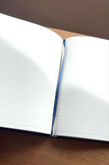 Caderno e capa dura forrada a tecido azul e com linhas