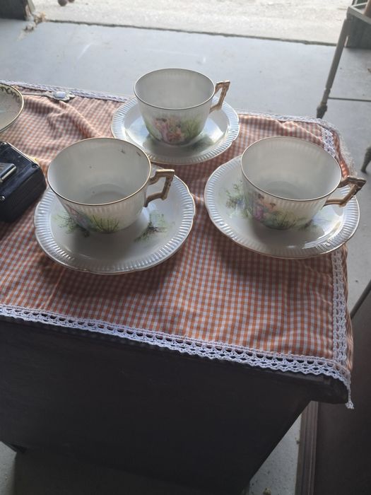 Three antique porcelain teacups with saucers