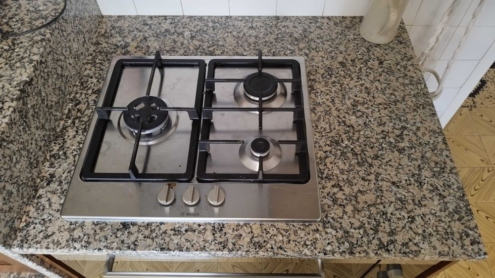 Conjunto de cozinha com bancada de mármore e madeira com forno e fogão