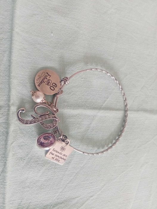 Pulseira em aço inoxidável, com vários berloques temáticos (charm bracelet)