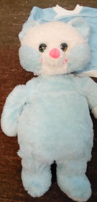 Peluche para brincar e guardar o pijama azul e branco.