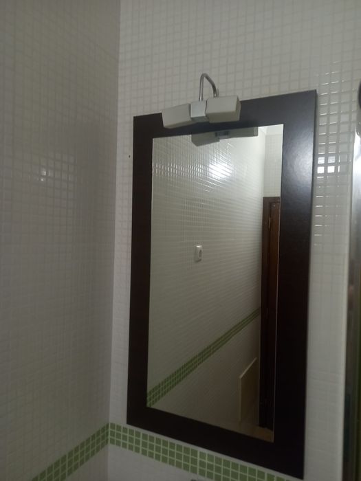 Móvel de casa de banho com lavatório e espelho.