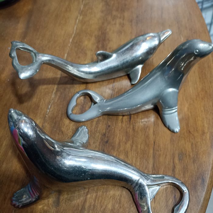 Abre-capsulas em inox, figura de animais marinhos.