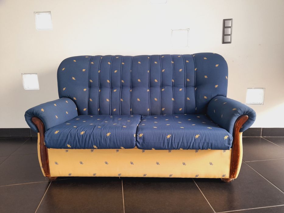 Sofá usado, mas ainda confortável e em bom estado. Com estampado azul