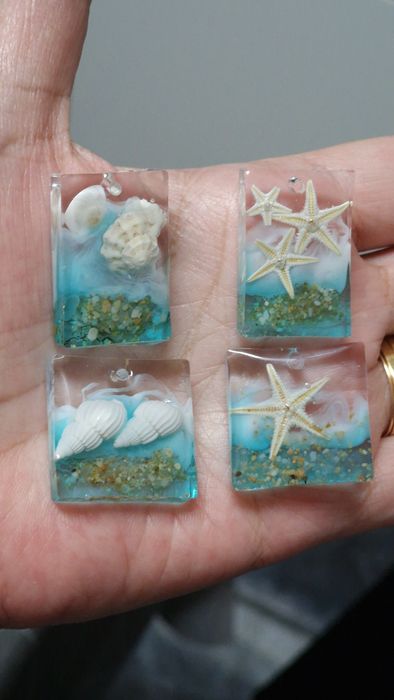 Pendentes artesanais feitos em resina com areia e conchas naturais.