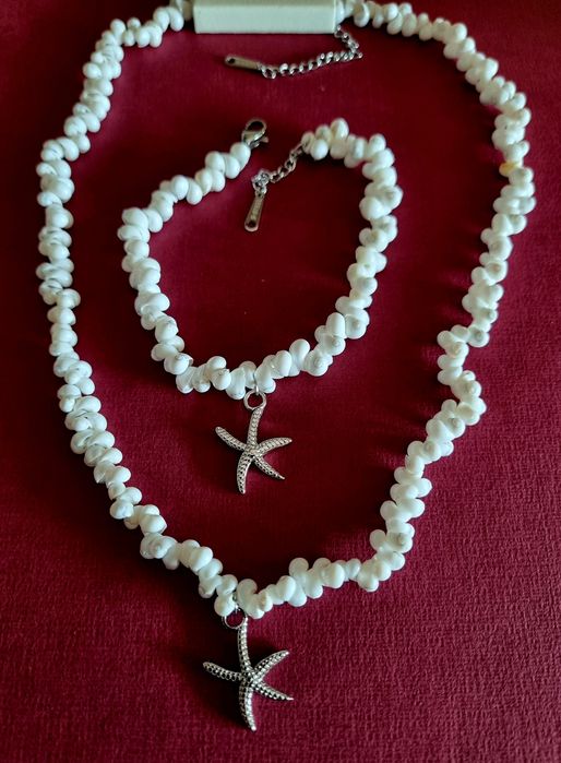 Conjunto branco (colar e pulseira), em aço, com estrela do mar prateada.
