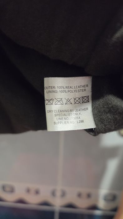 мужская коричневая кожаная куртка с карманами на груди и рукавах.