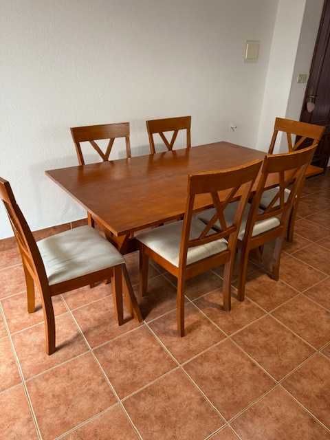 Conjunto de refeição com mesa e 6 cadeiras almofadadas.
