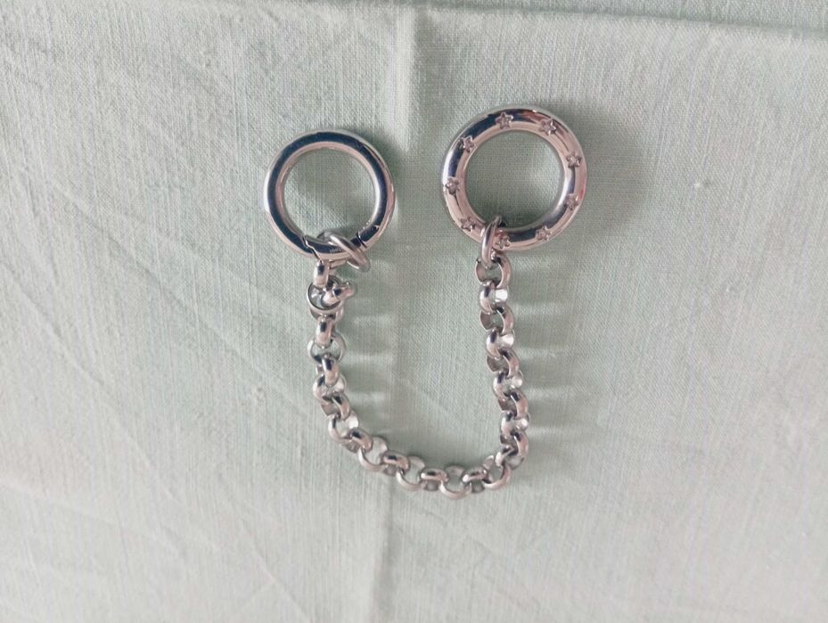 Pulseira em metal prateado, com aros e 2 argolas