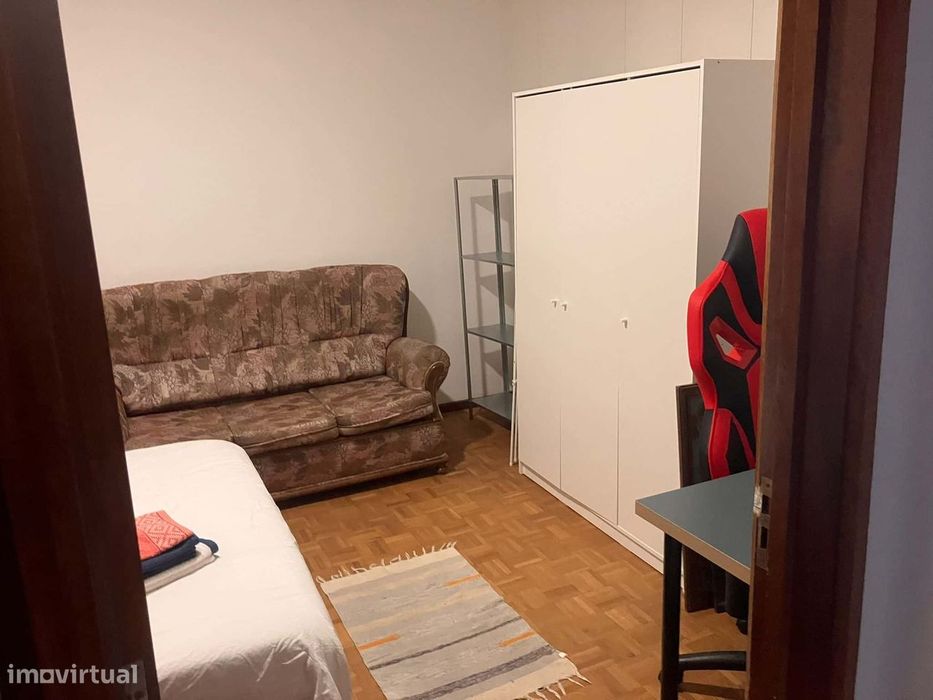 Spacious bedroom with a double bed, a desk and a couch