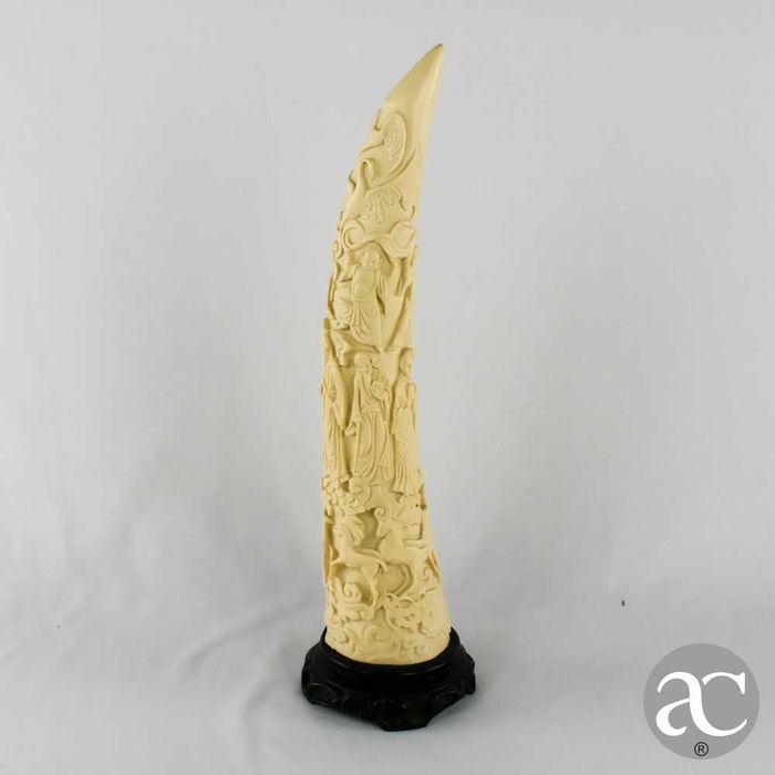 Escultura marfinite forma de dente de elefante com figuras orientais