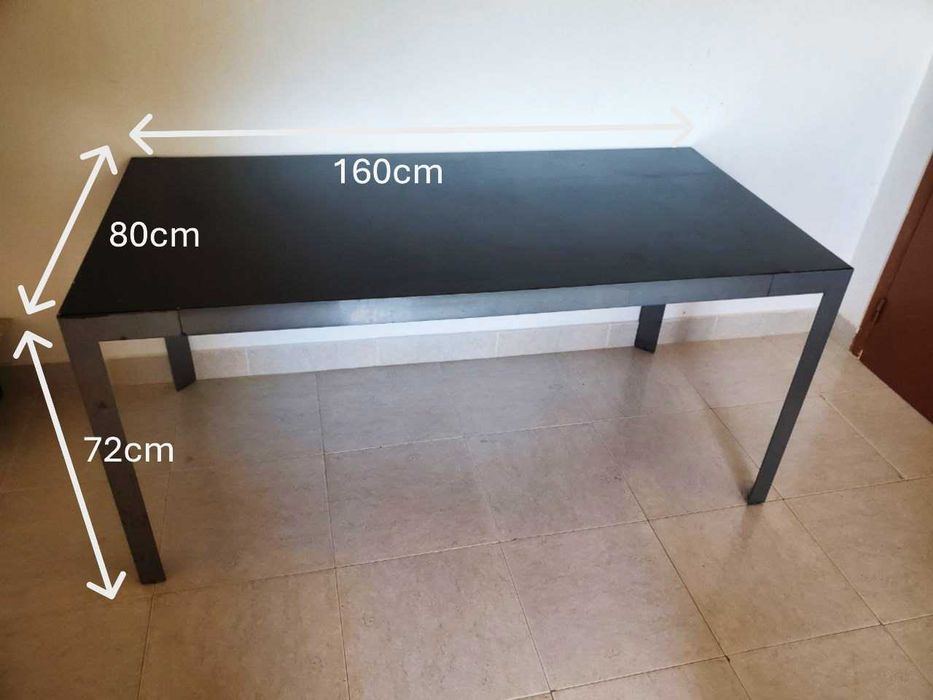 Mesa de jantar preta com estrutura em aço