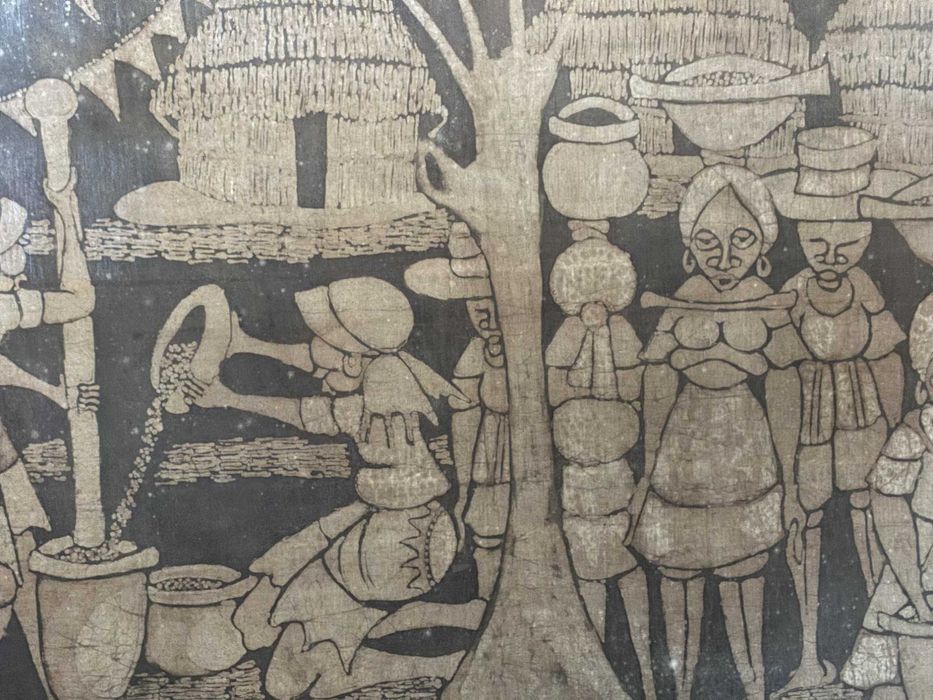 Batique com motivos rurais africanos com moldura em madeira dourada.