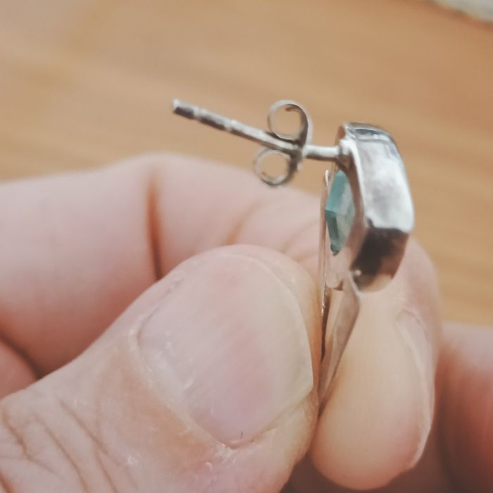 Brincos em prata com contraste e pedra azul.