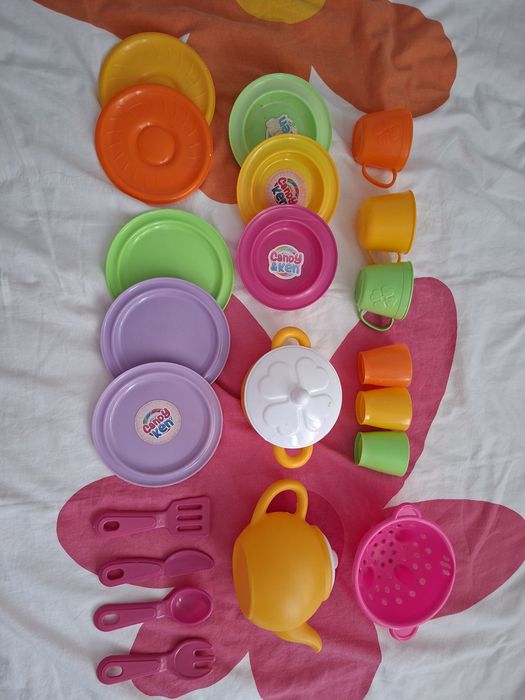 Microondas de brinquedo e loiça de brincar.