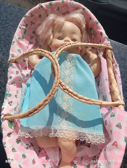 Boneca antiga num berço de vime