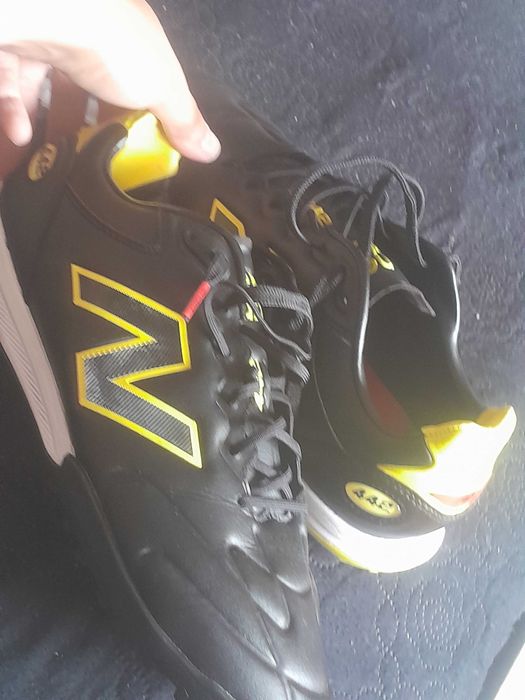 chuteira New Balance Furon V8 Elite TF (ou da versão Team correspondente), especificamente desenhada com uma sola TF (Turf) para relva sintética.