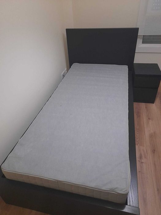 Cama individual, mesa de cabeceira e secretária