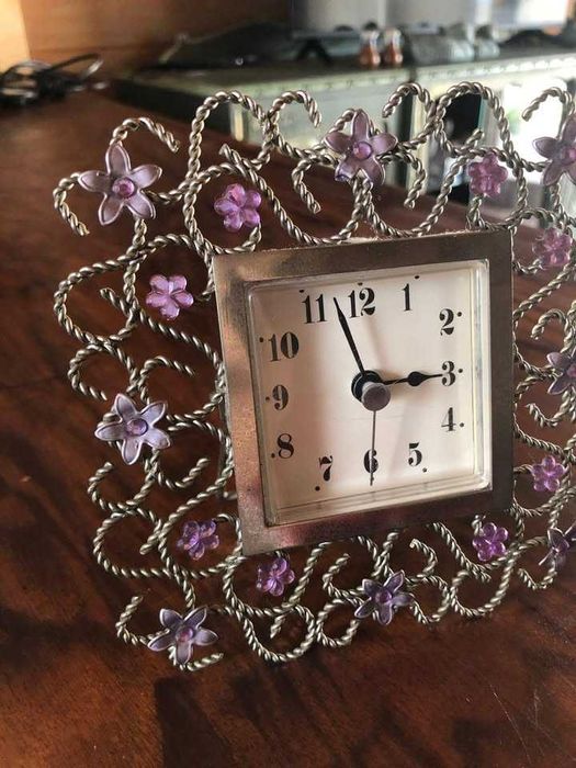 Relógio delicado em moldura trabalhada com flores em metal, bom estado