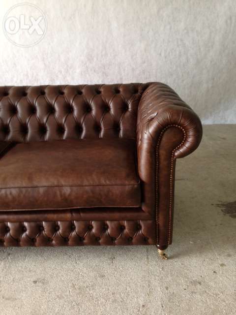 Sofá chesterfield em pele envelhecida com pé de rodízio- novo