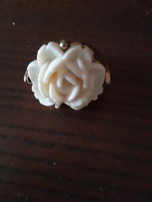 Anel dourado com uma grande flor em branco