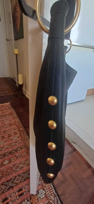 Mala preta em pele com tachas douradas