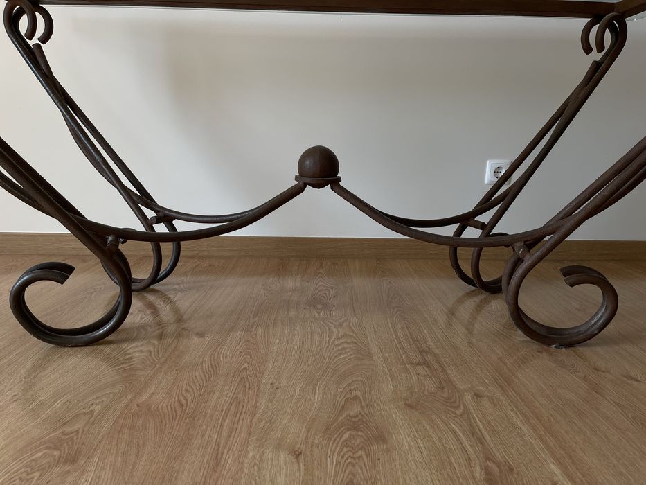 Mesa de jantar com tampo em vidro e base em ferro forjado