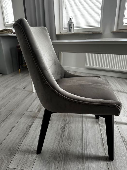 Szare krzesła tapicerowane z ciemnymi drewnianymi nogami – komplet