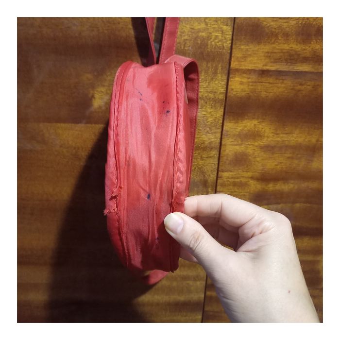 Маленька округла стьобана сумочка від Avon.