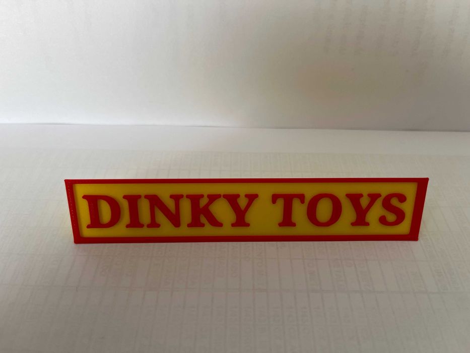Sinal DINKY TOYS p/expositor miniaturas, paral. triang.reg., amarelo