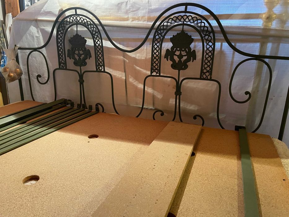 Cama de casal em ferro com colchão e estrado.