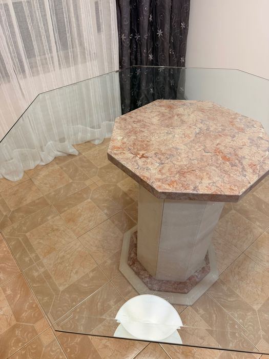 Mesa de jantar oitavada com base de mármore e tampo de vidro